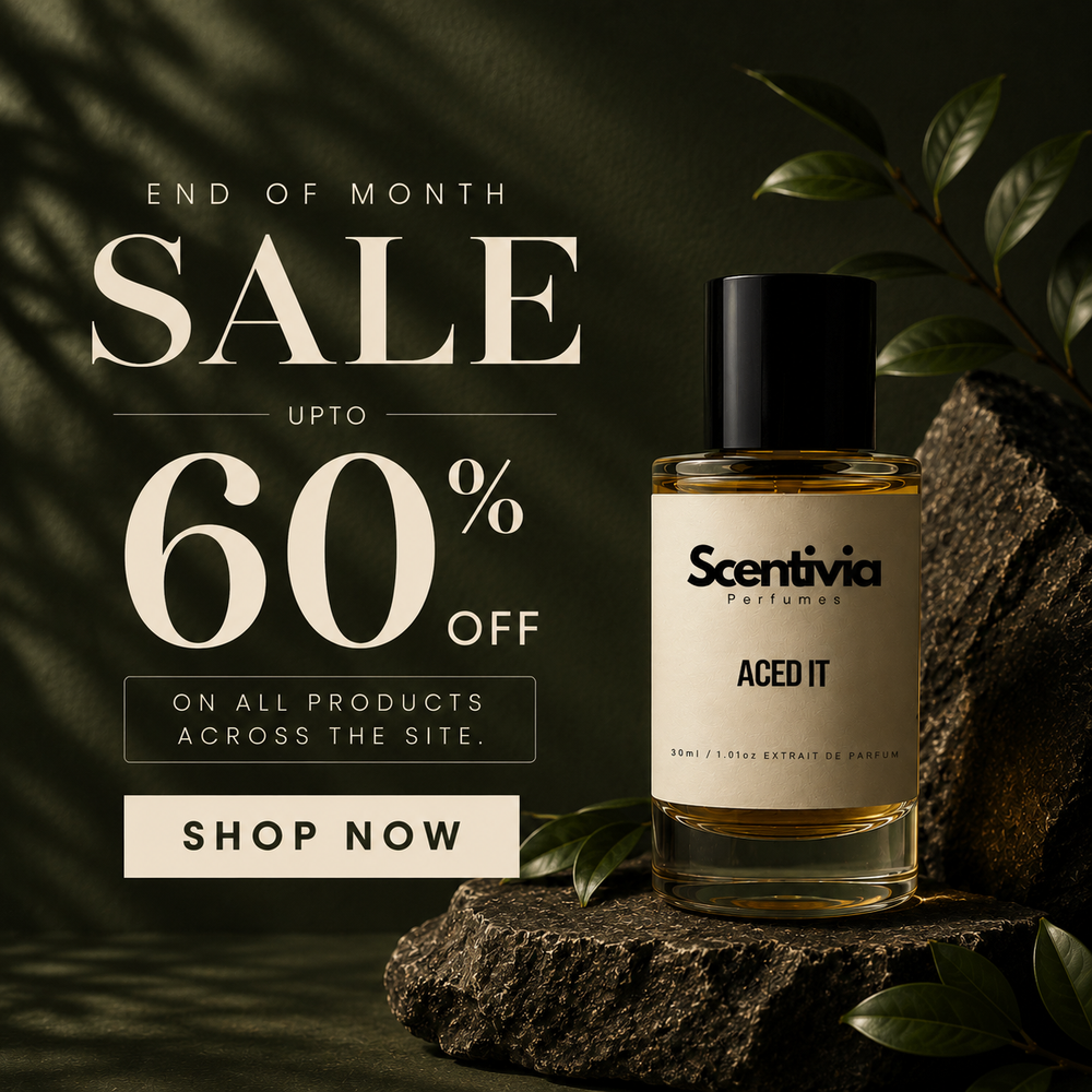 Scentivia Perfumes square banner for an End of Month Sale. Features a bottle of "Aced It" perfume displayed on a dark, textured rock with green leaves under mood lighting. Promotional text reads: "END OF MONTH SALE UPTO 60% OFF ON ALL PRODUCTS ACROSS THE SITE. SHOP NOW."