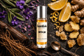 Fifth Lie roll on bottle with Lemon slices, Ginger, Violet flowers, Sage leaves, Vetiver roots and Amber crystals on dark background