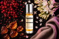 Neon Mirage roll on bottle with Red Berries, Tuberose flowers, Amber crystals and soft fabric on dark marble background