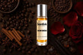Noir Brew Roll On bottle surrounded by Coffee Beans, Cinnamon, Rose Petals, Vanilla and rich warm gourmand notes
